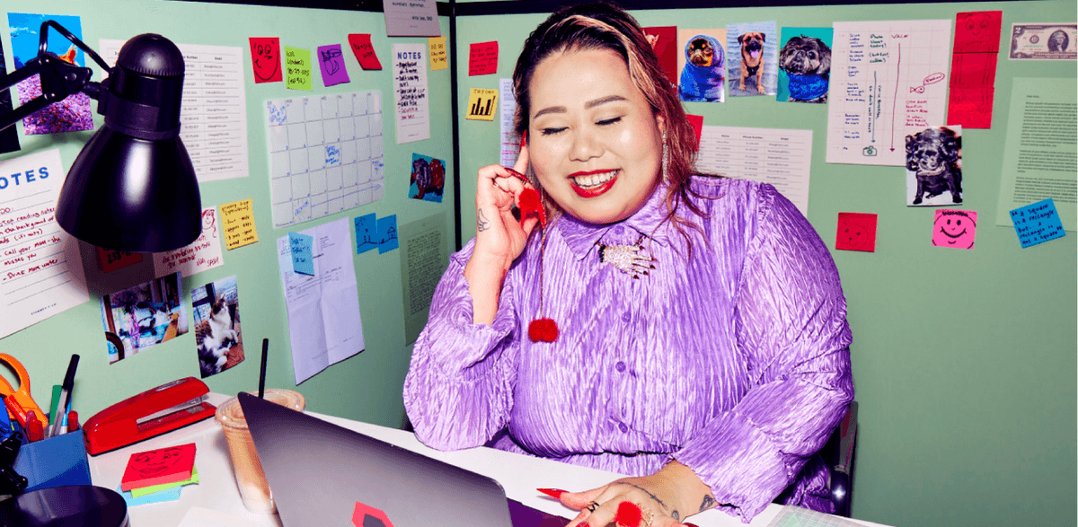 Person sitting and smiling at laptop